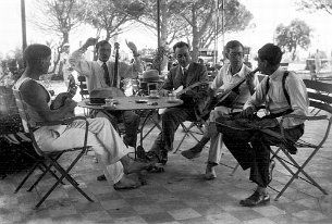 Django Reinhardt et Emile Savitry à Toulon Django Reinhardt et Emile Savitry dans un bar de la Rode à Toulon, Juillet 1931 Auguste «Gusti» Malha, Django Reinhardt, X, Emile Savitry (lunettes), Joseph...