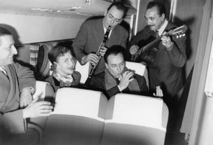Django Reinhardt avec Line Renaud 1952 1952 - Django Reinhardt - 391 - Django on board TWA flight. Django's guitar is a Selmer 488. Pierre Guillermin, Line Renaud, Hubert Rostaing, Loulou Gaste,...