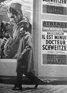 Django reinhardt marche dans la rue devant affiches de cinema Django reinhardt marche dans la rue devant affiches de cinema